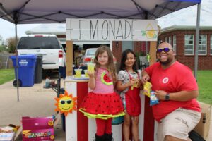 Salvation Army Disaster Worker poses with young girl at lemonade stand